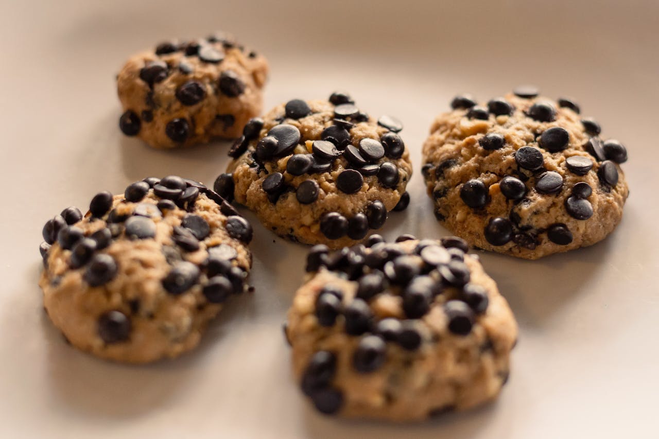 about-02 Close-up view of homemade chocolate chip cookies on a beige background, showcasing a crunchy texture.