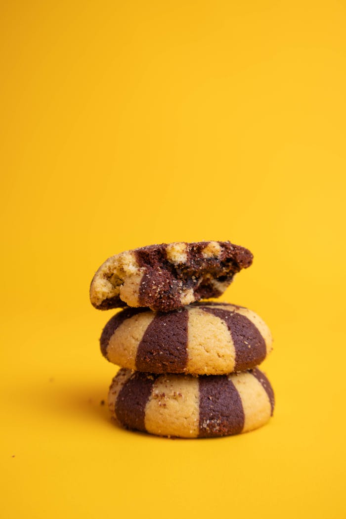 our-experience Delicious marble cookies stacked against a bright yellow backdrop, perfect for snack imagery.